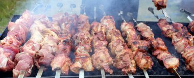 Açık ateşte ızgara sığır kebabı. Aşçı domuz kızartması yapıyor..