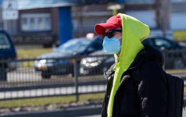 Açık havada yüz temizleme maskesi takan bir adam. Virüs koruması, Ekoloji, Hava kirliliği, Çevresel Farkındalık kavramı