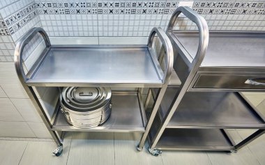 Ameliyat aletlerini sterilize etmek için kullanılan tıbbi büyük bir demir kap ameliyathanedeki bir rafta duruyor..