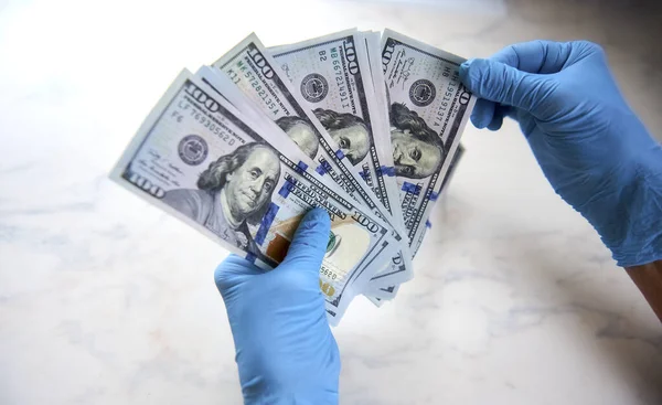 Güvenli para transferi. Lastik eldiveni teslim etmek para ister. Eller steril tıbbi eldivenlerde..