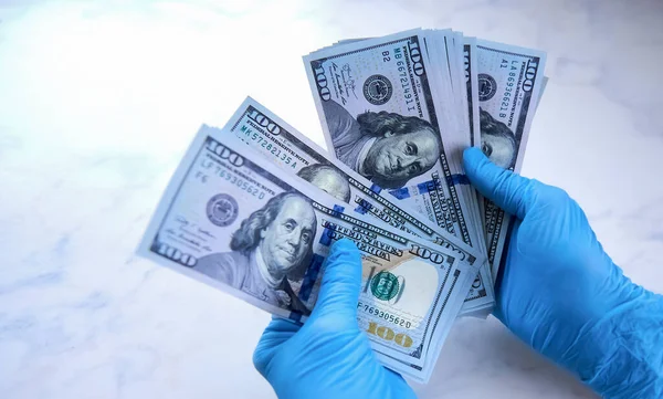 secure money transfer. hand in a rubber glove takes money. hands in sterile medical gloves.