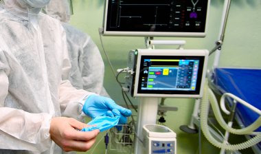 Coronavirüs salgını. Koruyucu maskeli ve solunum cihazlı, temiz takım elbiseli doktorların portresi.