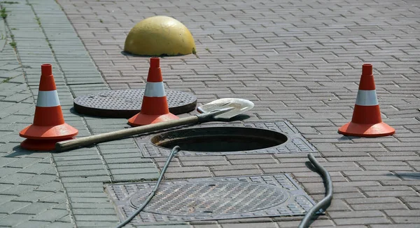 Offene Kanalluke Auf Der Straße Der Nähe Von Verkehrskegeln Das Stockbild