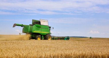 Çim biçme işlemi tarladaki buğdayı kaldırır. Hasatçı, tarladaki olgunlaşmış buğday mahsulünü temizler.