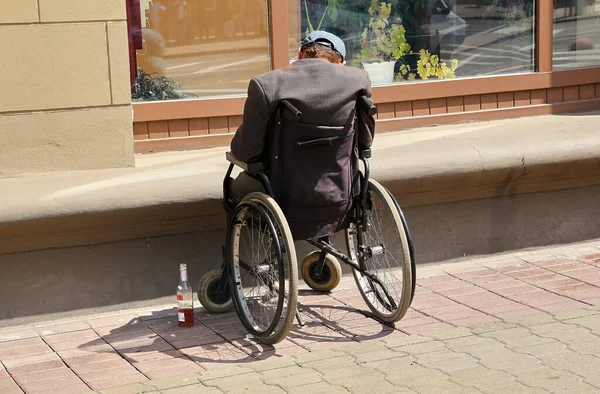 On the street, a disabled person is sleeping in a wheelchair after drinking alcohol.