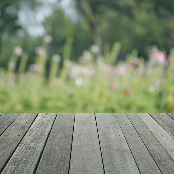 Suelo de madera viejo vacío con flor rosa borrosa y árbol, para su — Foto de Stock