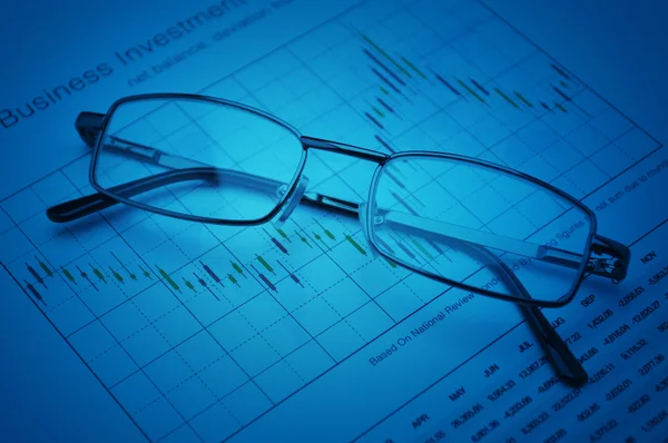 Glasses on stock market graph, financial concept — Stock Photo, Image