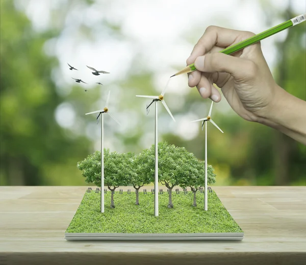 Hand with pencil drawing wind turbines, trees and birds from an — Stock Photo, Image