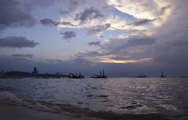 Construction crane at sea and city over sunset sky, Pattaya Thai — Stock Photo, Image