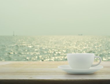 Beyaz Kupası bulanık deniz dalgaları bokeh Light ile ahşap tablo