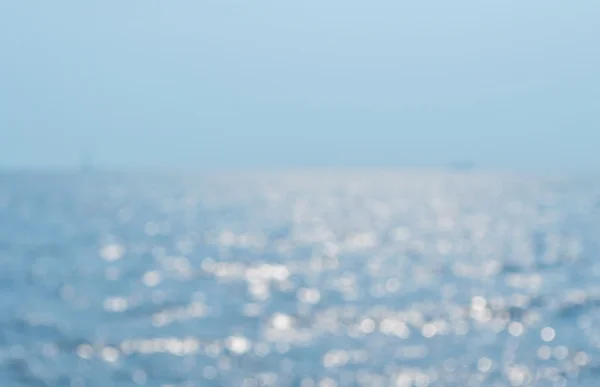 Размытые морские волны с боке света — стоковое фото