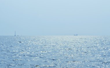 Deniz ve mavi gökyüzü üzerinde tekne siluet