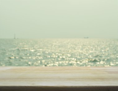 Bokeh ışık, gree bulanık deniz dalgaları ile boş ahşap masa