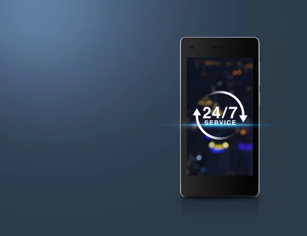Icono de servicio de 24 horas en la pantalla de la torre de la ciudad de luz borrosa en moderno — Foto de Stock