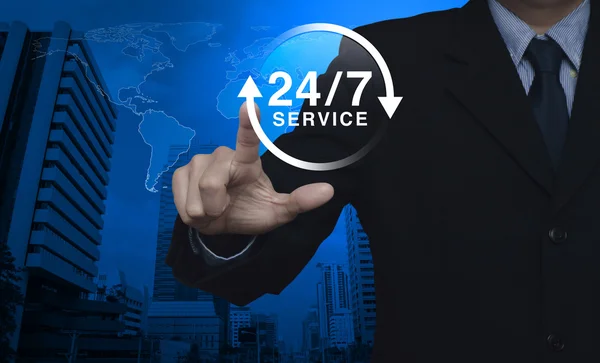 Businessman pressing button 24 hours service icon over map and c — Stock Photo, Image