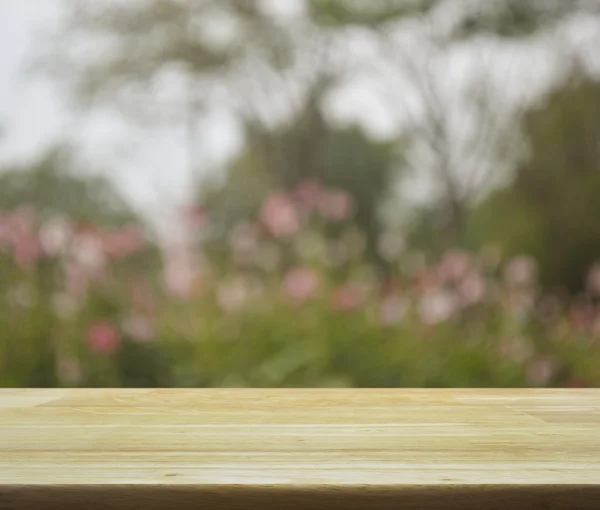 Mesa de madera vacía con flor rosa borrosa y árbol para backgro — Foto de Stock