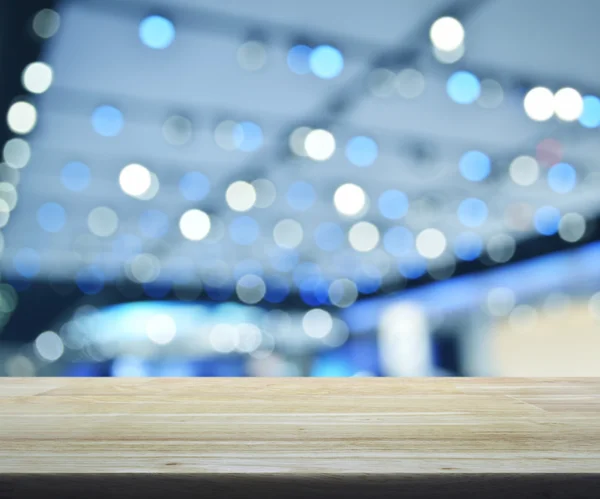 Mesa de madera vacía sobre luz desenfocada y sombra de m comercial —  Fotos de Stock