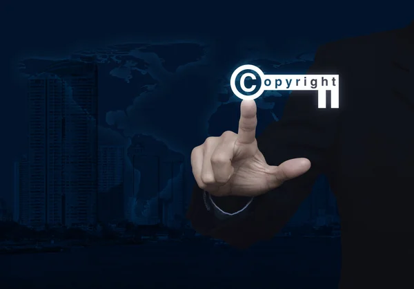 Businessman pressing copyright key icon over map and city tower — Stock Photo, Image