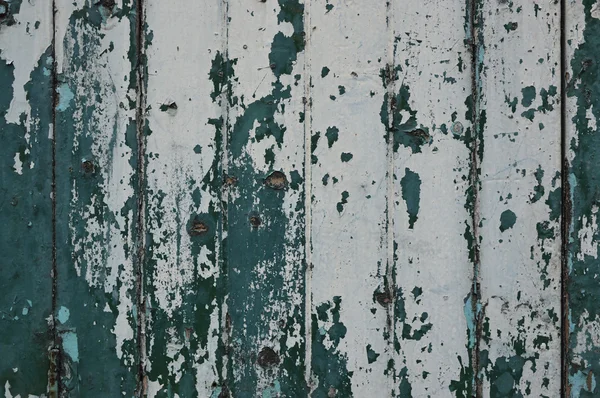 Пилинг краски белого и зеленого цвета на старой деревянной стене — стоковое фото