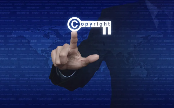 Businessman pressing copyright key icon over digital world map a — Stock Photo, Image