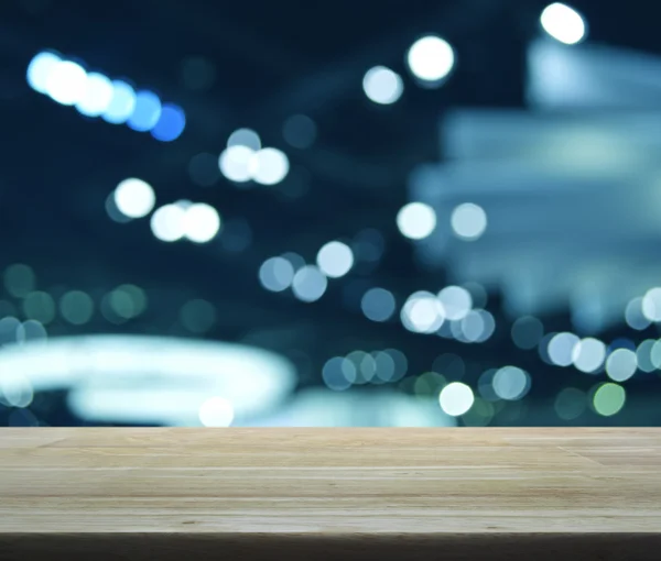 Mesa de madera vacía sobre luz desenfocada y sombra de m comercial —  Fotos de Stock