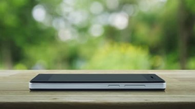 Kapalı devre kamera yassı simgesi, modern akıllı cep telefonu ekranında, parktaki bulanık yeşil ağacın üzerinde, iş güvenliği ve güvenlik online konsepti.