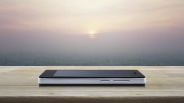 Kapalı devre kamera yassı simgesi modern akıllı cep telefonu ekranında ahşap masa üzerinde ve günbatımında gökdelen, klasik tarz, iş güvenliği ve güvenlik online konsepti