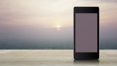 Harita pin noktası konumu düğmesi üzerinde modern akıllı cep telefonu ekranı ahşap masa üzerinde ve günbatımında gökdelen, klasik stil, harita işaretleyici çevrimiçi konsept
