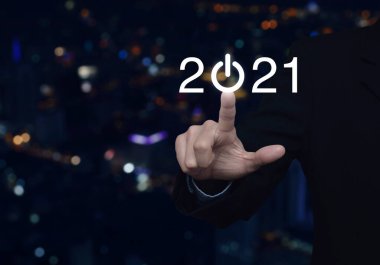 2021 'e basan iş adamı, bulanık renkli gece lambası, modern şehir kulesi ve gökdelen üzerinde iş hayatına yeni bir imaj kazandırıyor.