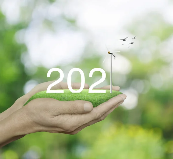2021 Λευκό Κείμενο Ανεμογεννήτρια Πράσινο Γρασίδι Τομέα Στον Άνθρωπο Χέρια — Φωτογραφία Αρχείου