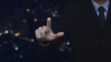 İş adamı, bulanık gece ışığı, modern şehir kulesi ve gökdelen, iş iletişimi kavramının üzerine mikrofon resmi basıyor.