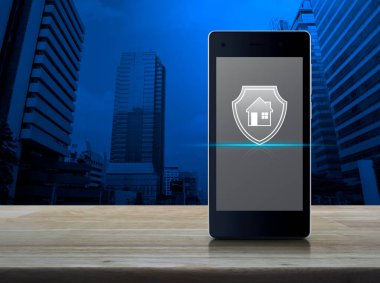 Ofis kulesi, gökdelen, iş yeri sigortası ve güvenlik online konsepti üzerinde ahşap masa üzerinde modern akıllı cep telefonu ekranı simgesi olan ev