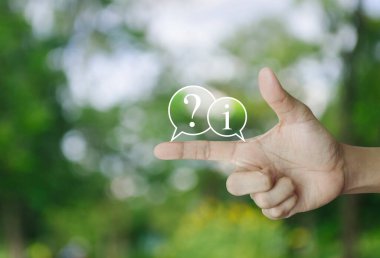 Soru işareti ve bilgi sohbet simgesi parktaki bulanık yeşil ağaç, iş müşteri hizmetleri ve çevrimiçi konsepti desteklemek üzerine parmak üzerine simge