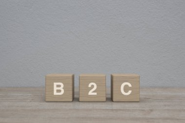 B2C harfi blok küpleri üzerinde ahşap masa üzerinde beyaz duvar arkaplanı üzerinde iş müşteri pazarlama ve strateji konsepti