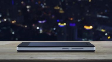 Modem akıllı cep telefonu ekranında, renkli gece lambası şehir kulesi ve gökdelen, iş güvenliği ve güvenlik online konsepti üzerinde, kapalı ahşap masadaki mobese üzerine kapalı kamera yassı simgesi