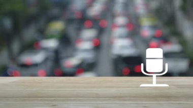 Mikrofon yassı simgesi ahşap masa üzerinde yoğun saatlerde arabalar ve şehirlerdeki yollar ile iş iletişimi kavramı