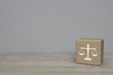 Hukuk dairesi simgesi blok küp üzerinde ahşap masa üzerinde beyaz duvar arkaplanı üzerinde, iş hukuku hizmet kavramı