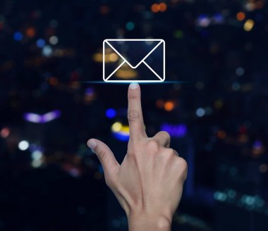 Bulanık renkli gece ışığı, modern şehir kulesi ve gökdelen üzerinde el ile e-posta düz simgesi, iş bizimle çevrimiçi konsept iletişim kurar