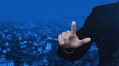 İş adamı modern ofis kulesi, sokak ve otoyol, iş bankacılığı online konsepti üzerine banka ikonuna basıyor