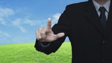 İşadamı güvenlik kalkanına mavi gökyüzü, teknoloji internet siber güvenliği ve anti virüs çevrimiçi konsepti ile yeşil çimen sahasının üzerinde düz simge ile basıyor