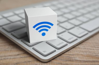 Wi-fi düz simge beyaz blok küp üzerinde modern bilgisayar klavyesi ahşap masa üzerinde, teknoloji internet iletişim konsepti