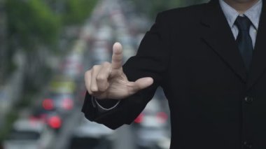 İş adamı, trafiğin yoğun olduğu saatte e-posta adresi simgesine basıyor. Şehirde arabalar ve yollar var. İş dünyası bizimle online konsept üzerinden bağlantı kuruyor.