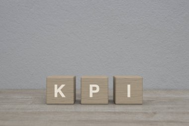 KPI harfi blok küpleri üzerinde tahta masa üzerinde beyaz duvar arkaplanı üzerinde, Anahtar Performans Göstergesi iş hedefi kavramı