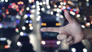 Motorcycle with shield flat icon on finger over blur colourful night traffic jam road with cars in city, Business motorbike insurance concept