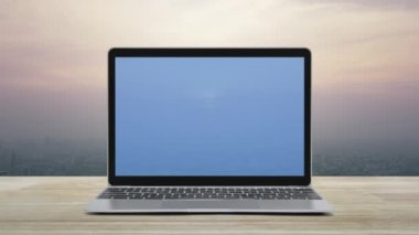 Modern dizüstü bilgisayar ekranındaki mikrofon yassı simge şehir kulesinin üzerindeki ahşap masa üzerinde ve günbatımında gökdelen, klasik tarz, iş iletişimi online konsept