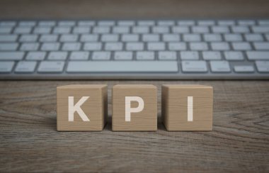 KPI harfi blok küpleri üzerinde ahşap masa üzerinde bilgisayar klavyesi, Anahtar Performans Göstergesi iş hedefi kavramı
