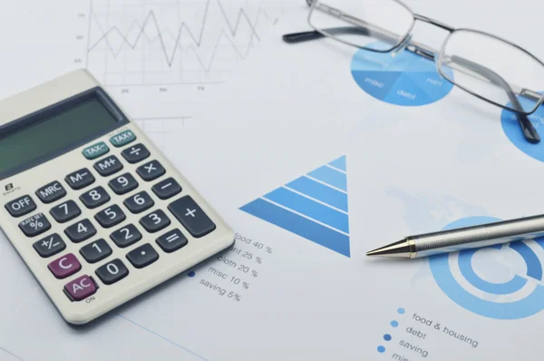 Ручка, калькулятор, окуляри на фінансовому графіку — стокове фото