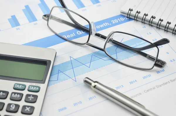 Gasses pen and calculator on financial chart and graph — Stock Photo, Image