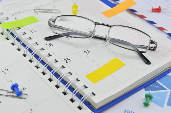 Planejador mensal com óculos e postá-lo no gráfico de papel — Fotografia de Stock