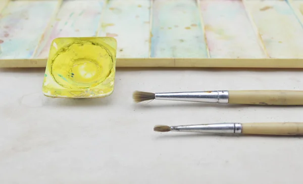 Old paintbrush with watercolor on paper — Stock Photo, Image